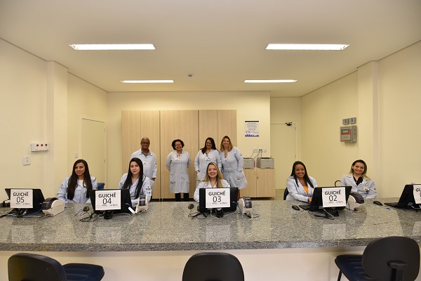 #PraCegoVer: Na imagem, fotografia dos funcionários da saúde. Todos estão sorrindo, alguns estão em pé e outros estão sentados.